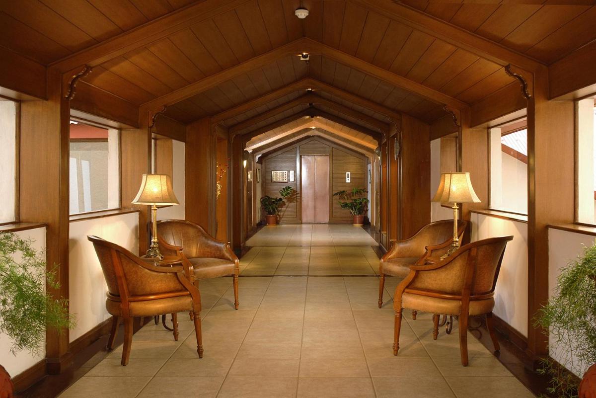 a hallway with chairs and a hallway with a door at Radisson Hotel Shimla in Shimla