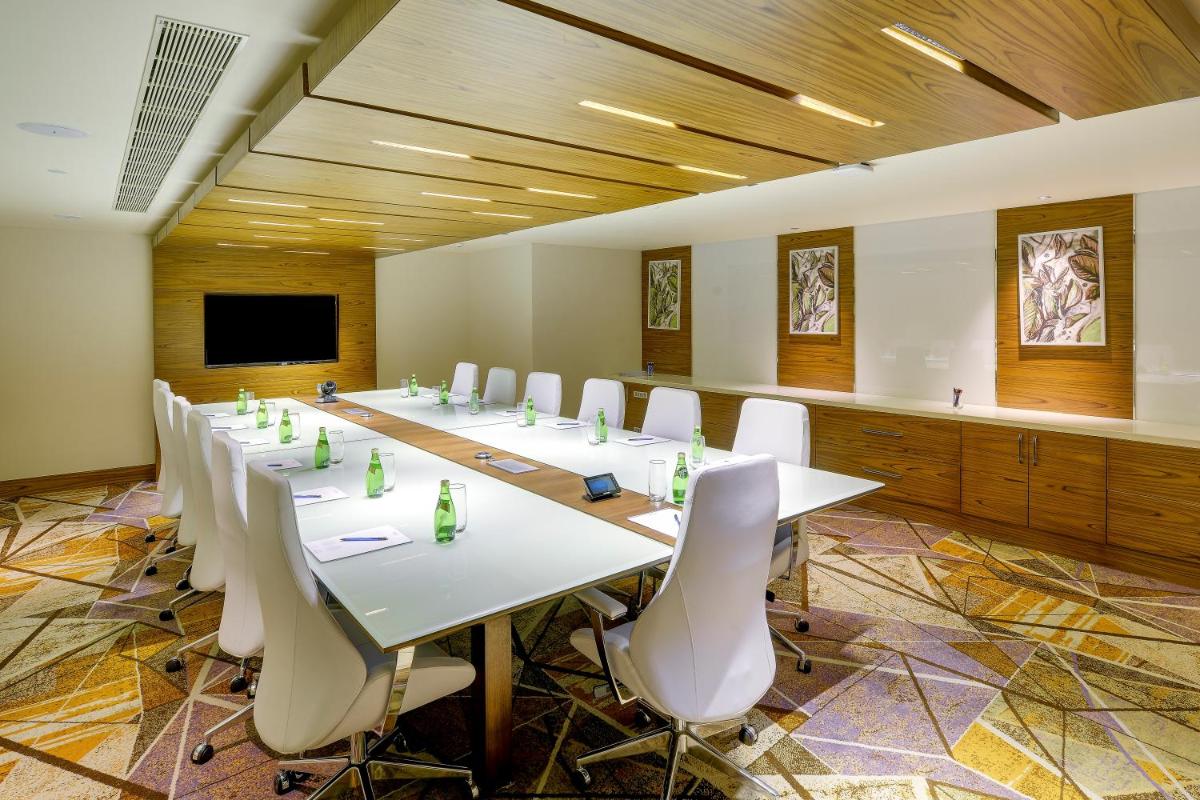 a large conference room with white tables and chairs at Novotel Kochi Infopark in Cochin