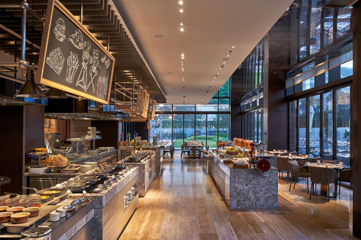 a restaurant with a buffet line with food on display at The Den, Bengaluru in Bengaluru a restaurant with a buffet line with food on display at The Den, Bengaluru in Bengaluru