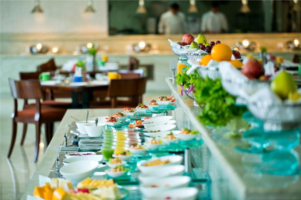 a buffet line with plates and bowls of food at The Lalit Jaipur in Jaipur