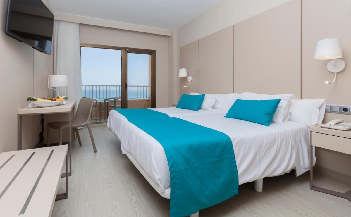 Una habitación de hotel con una cama grande y un balcón. en Hotel & Spa Peñiscola Palace, en Peñíscola