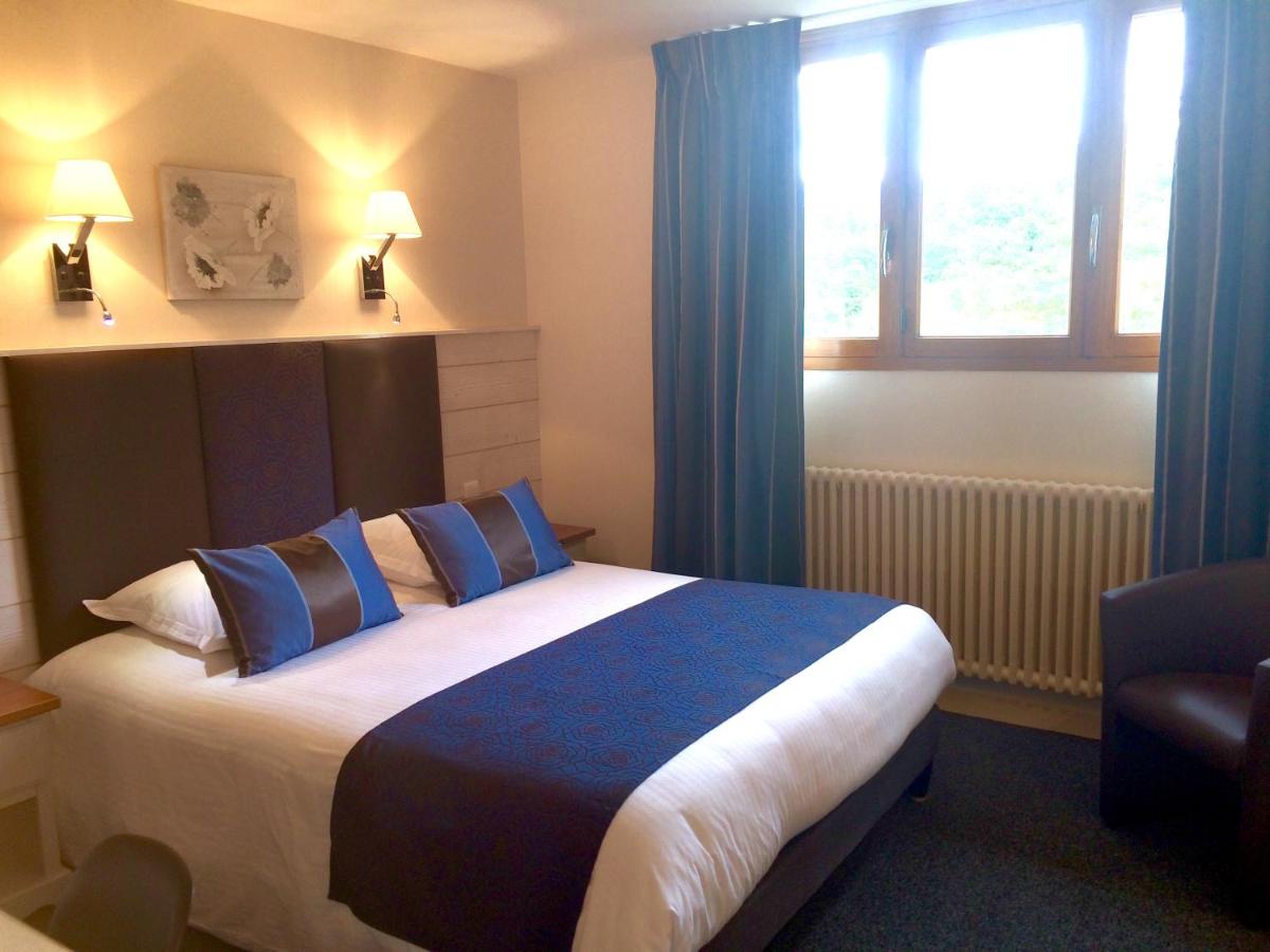 - une chambre avec un lit doté de rideaux bleus et d'une fenêtre dans l'établissement Hôtel Spa & Restaurant Ô Pervenches, à Chambéry