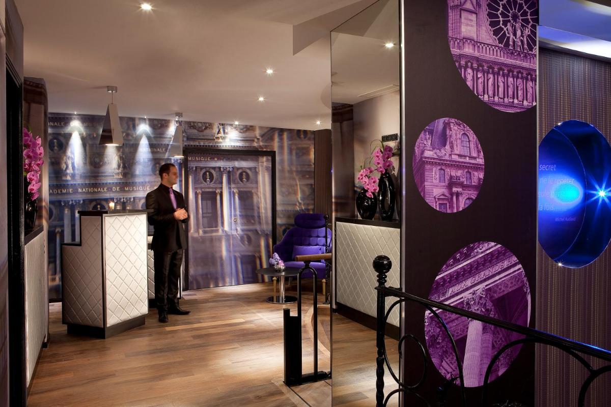 un homme en costume debout à un comptoir dans une pièce dans l'établissement Secret de Paris - Hotel & Spa, à Paris