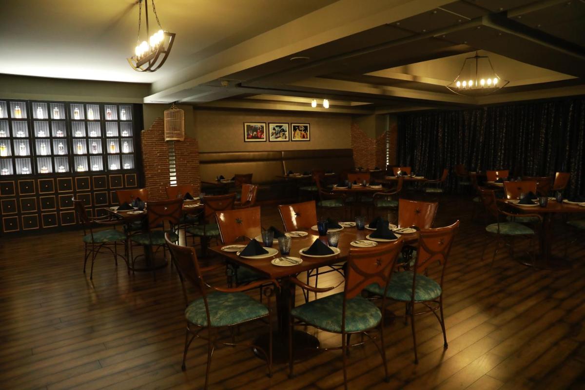 a restaurant with tables and chairs in a room at Radisson Blu Hotel Pune Kharadi in Pune