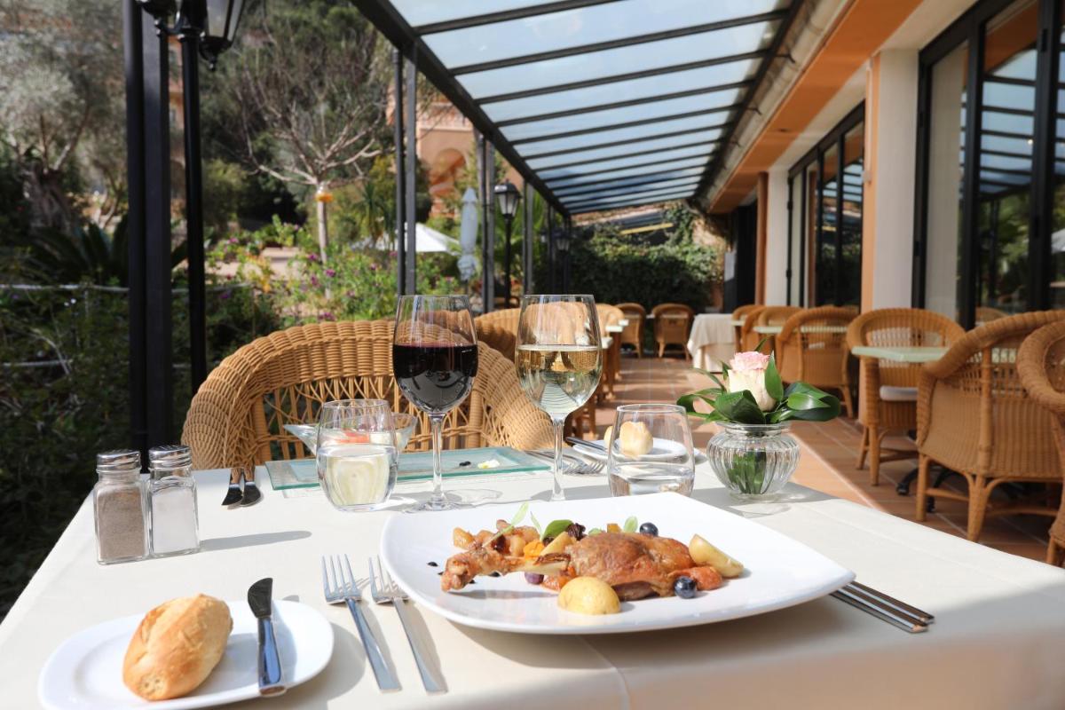 Una mesa con un plato de comida y copas de vino. en Mon Port Hotel & Spa, en Puerto de Andratx