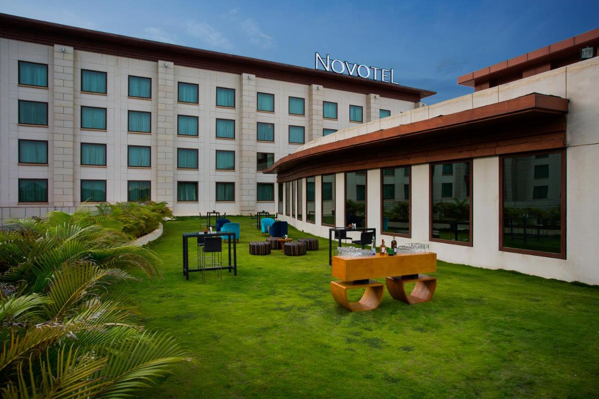 a large building with a grass yard in front of it at Novotel Hyderabad Airport in Hyderabad
