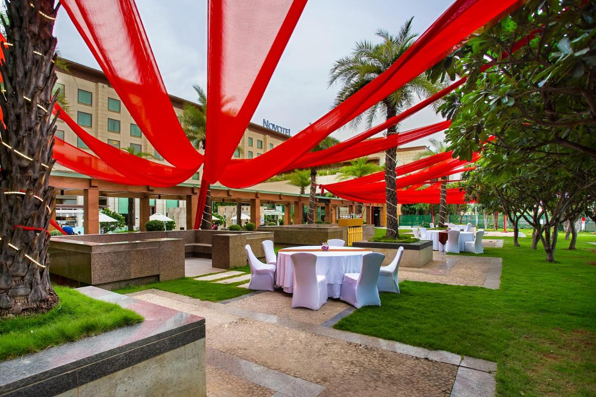 a group of tables and chairs in a park at Novotel Hyderabad Airport in Hyderabad