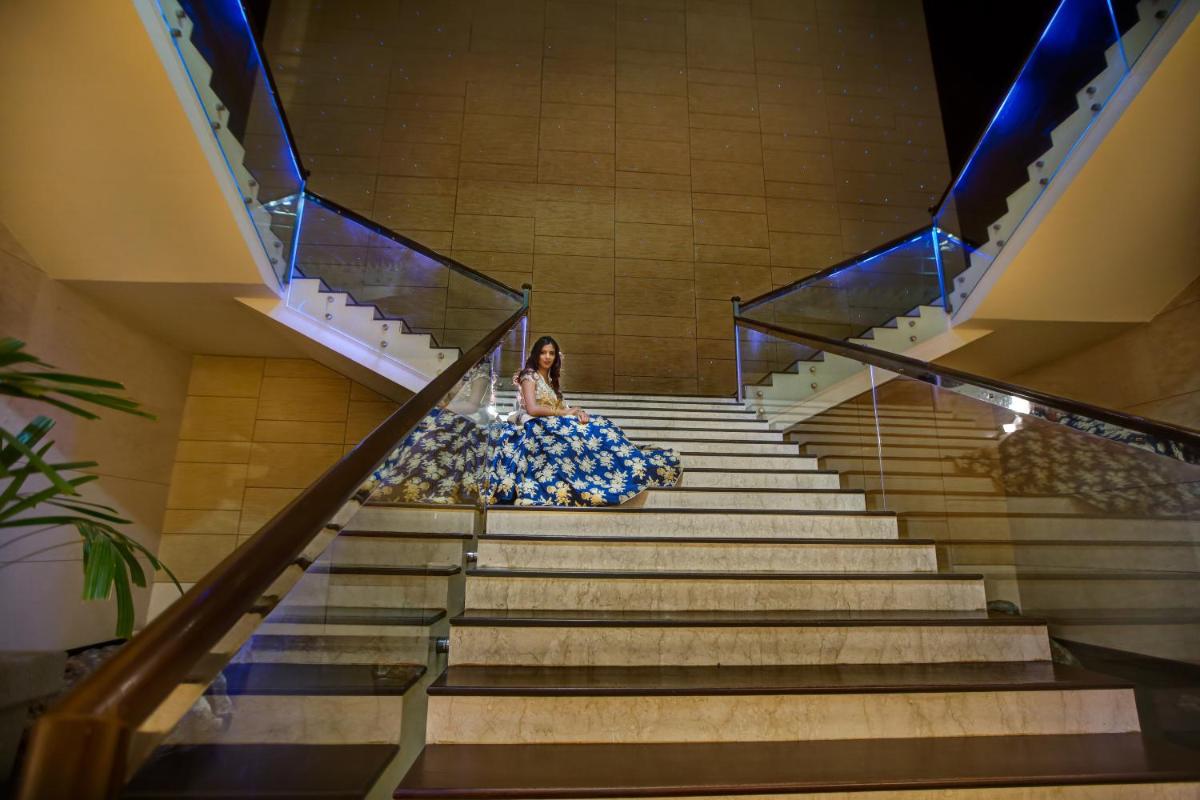 a woman in a blue dress sitting on the stairs at Novotel Hyderabad Airport in Hyderabad