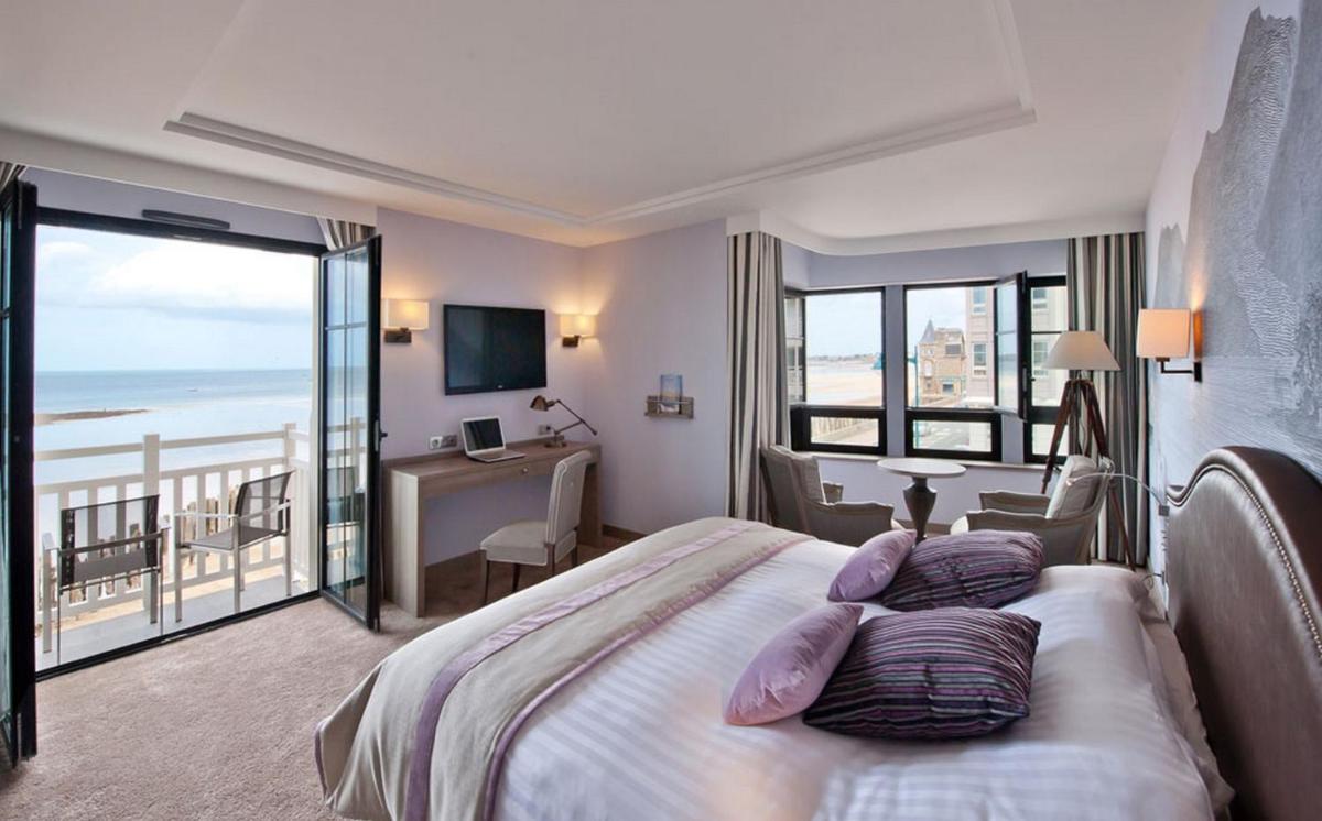 une chambre avec un lit avec vue sur l'océan dans l'établissement Hôtel Le Nouveau Monde, à Saint-Malo