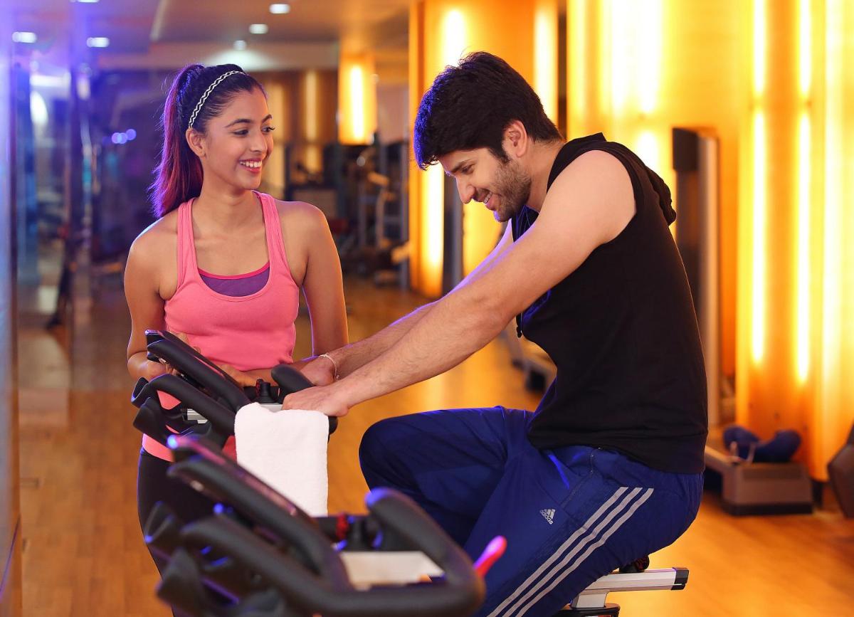 a man and a woman on a treadmill in a gym at Novotel Hyderabad Airport in Hyderabad
