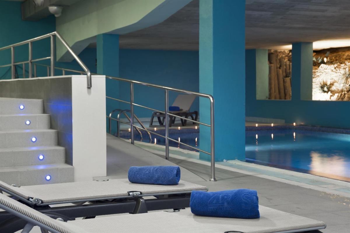 una piscina con paredes azules y escaleras junto a una piscina en 4R Salou Park Resort I, en Salou