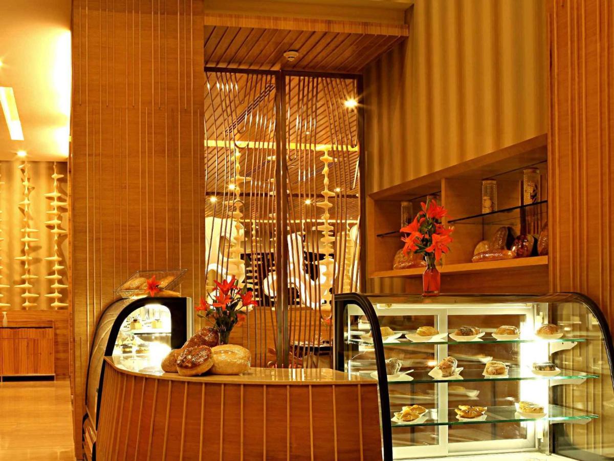a bakery with a glass counter with food on it at The Metropolitan Hotel & Spa New Delhi in New Delhi