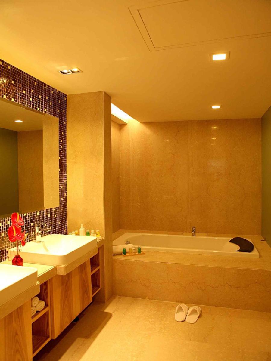 a bathroom with two sinks and a bath tub at The Metropolitan Hotel & Spa New Delhi in New Delhi