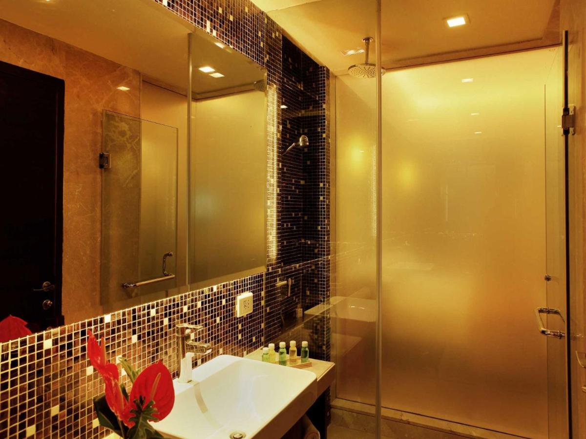 a bathroom with a glass shower and a sink at The Metropolitan Hotel & Spa New Delhi in New Delhi