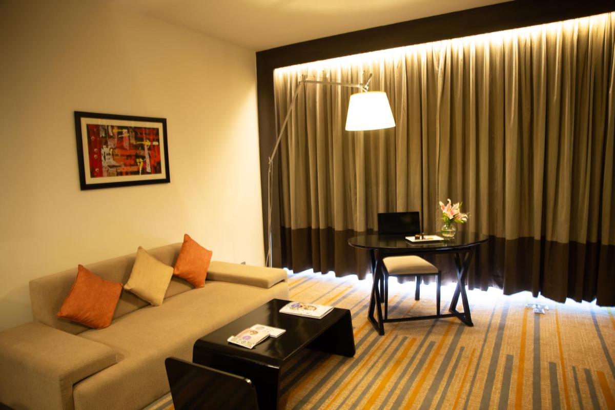 a living room with a couch and a table at Novotel Kolkata Hotel and Residences in Kolkata a living room with a couch and a table at Novotel Kolkata Hotel and Residences in Kolkata