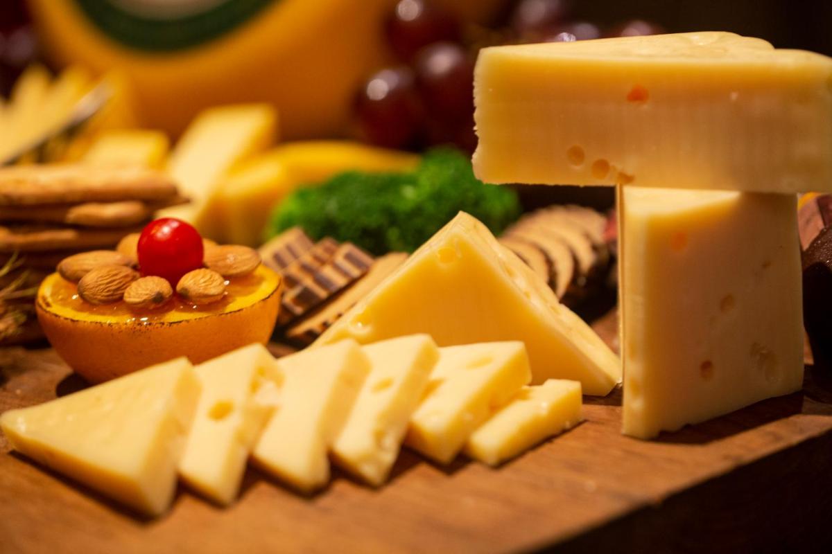 a bunch of different types of cheese on a table at President - IHCL SeleQtions in Mumbai