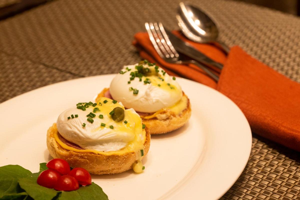 two donuts with cream cheese and green sprinkles on a plate at President - IHCL SeleQtions in Mumbai