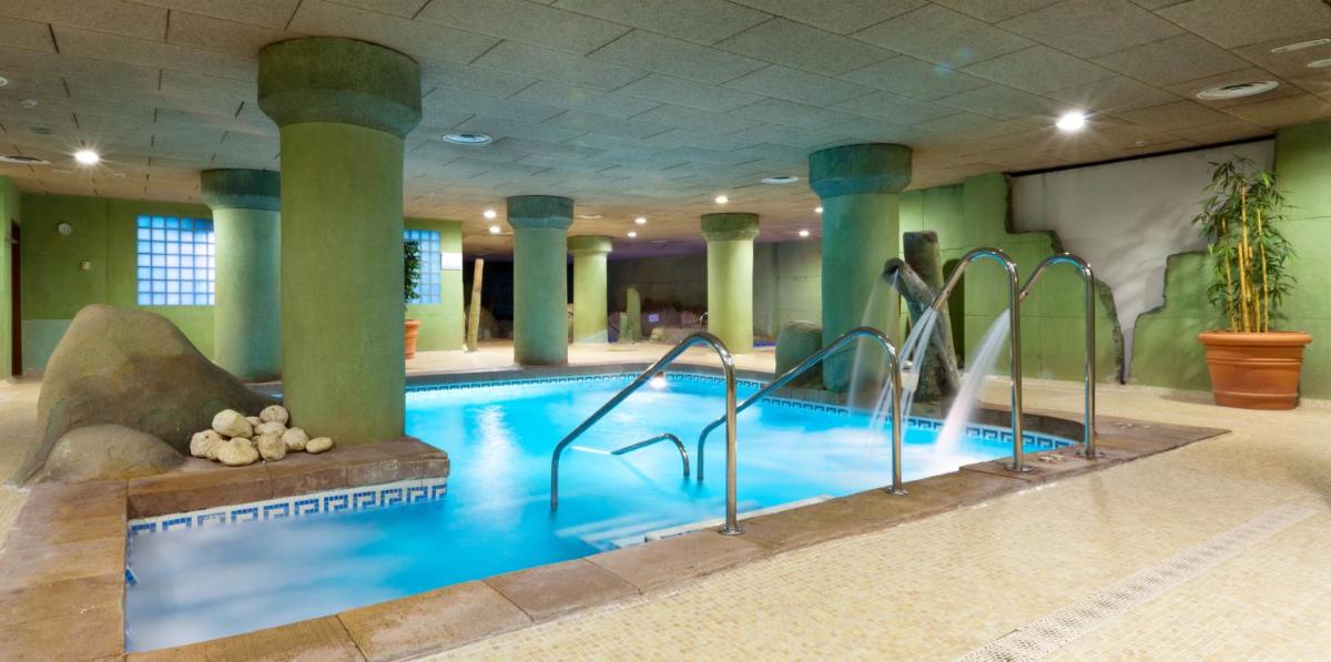 Una gran piscina en un edificio con columnas. en Senator Granada, en Granada