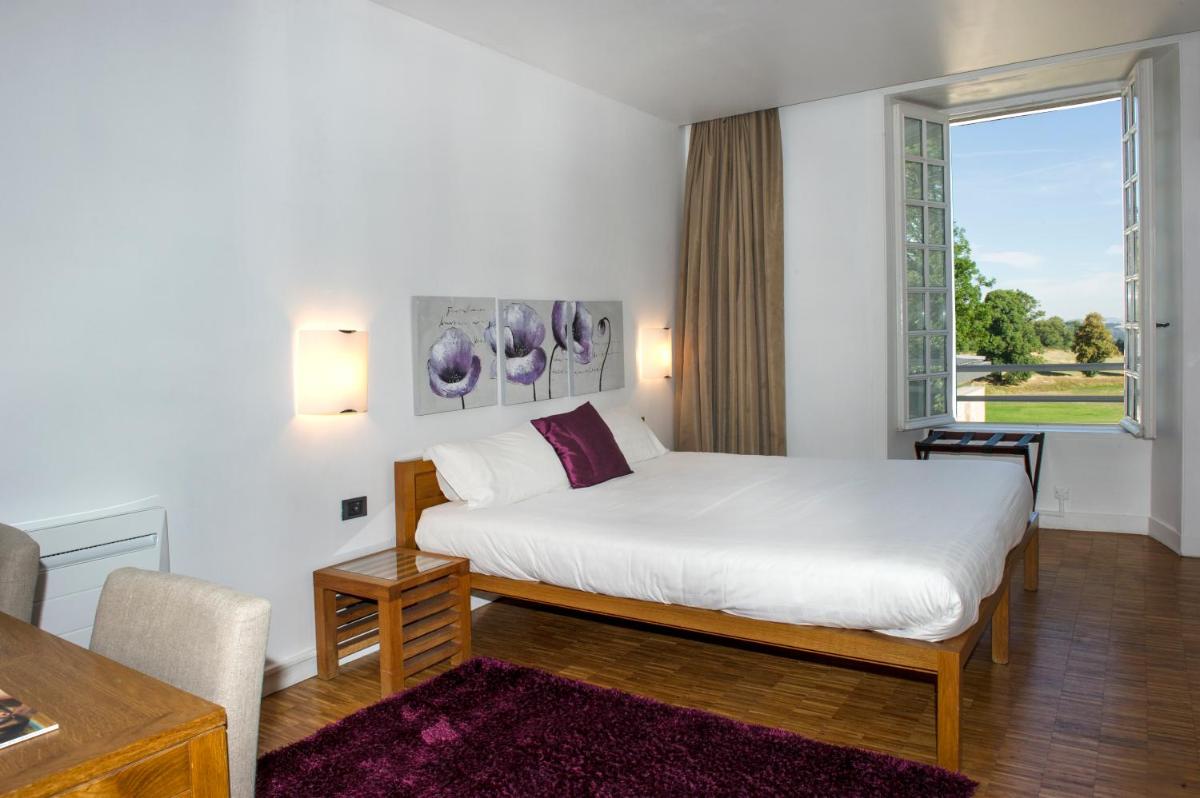 une chambre avec un lit blanc et une fenêtre dans l'établissement Domaine De Barres, à Langogne