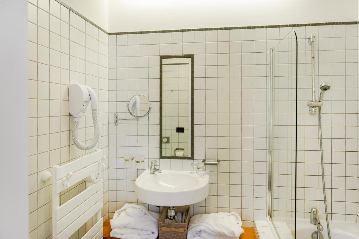une salle de bain blanche avec un lavabo et une douche dans l'établissement Domaine De Barres, à Langogne