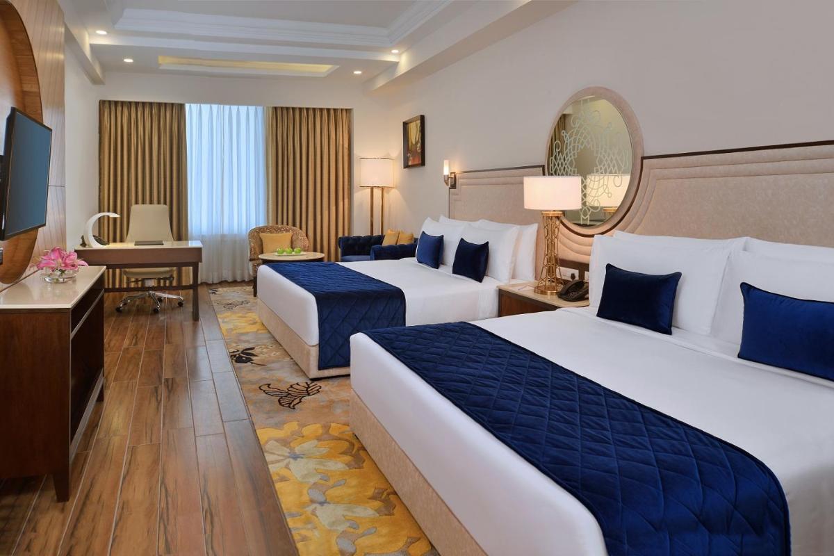 a hotel room with two beds and a television at Radisson Chandigarh Zirakpur in Chandīgarh
