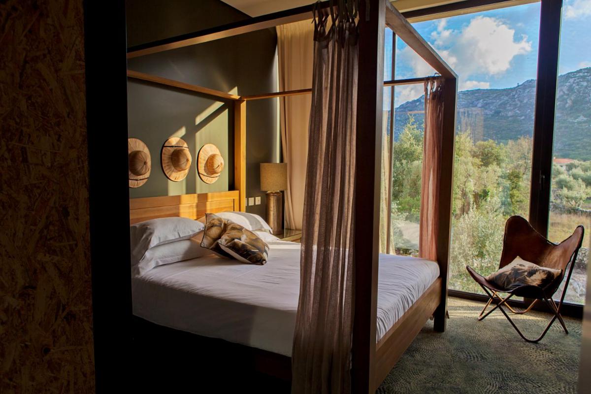 um quarto com uma cama e uma grande janela de vidro em Cooking and Nature - Emotional Hotel em Alvados
