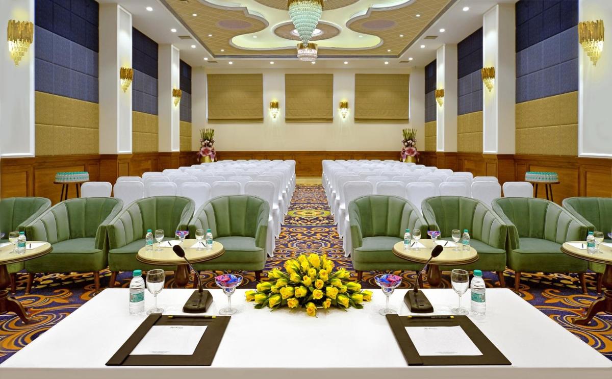 a banquet hall with white tables and green chairs at Radisson Chandigarh Zirakpur in Chandīgarh
