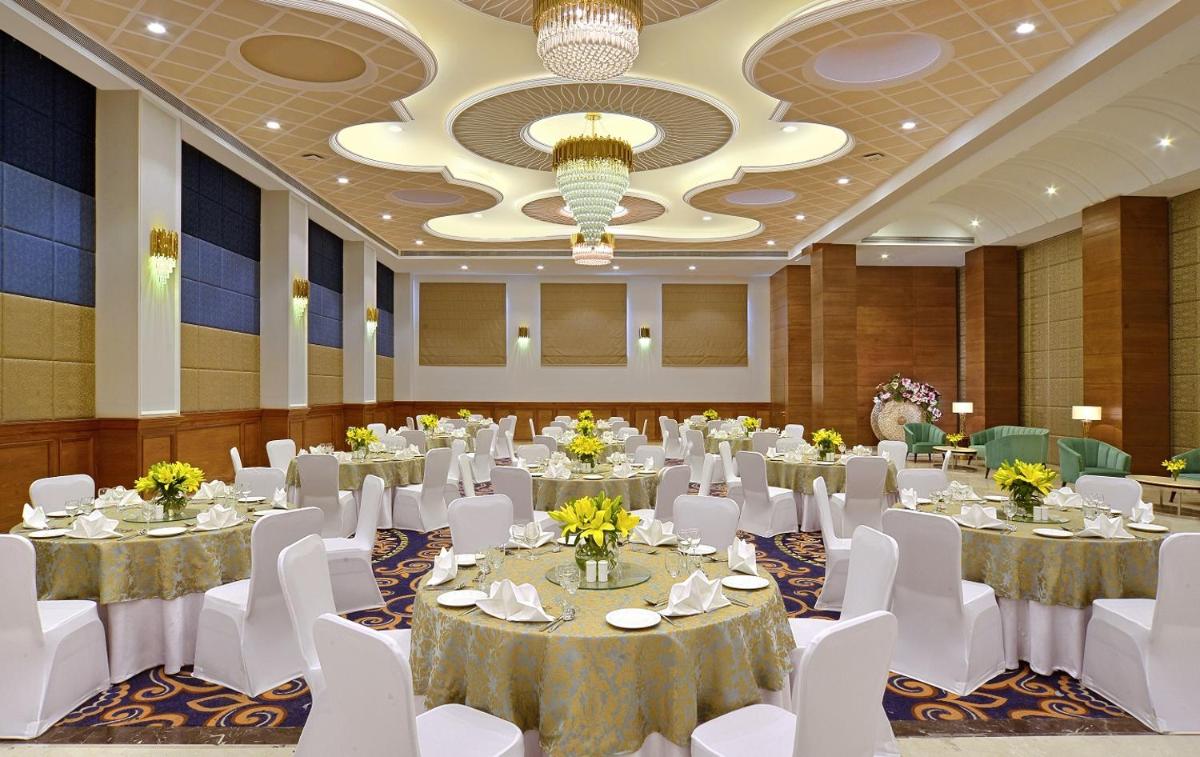 a banquet hall with white tables and white chairs at Radisson Chandigarh Zirakpur in Chandīgarh