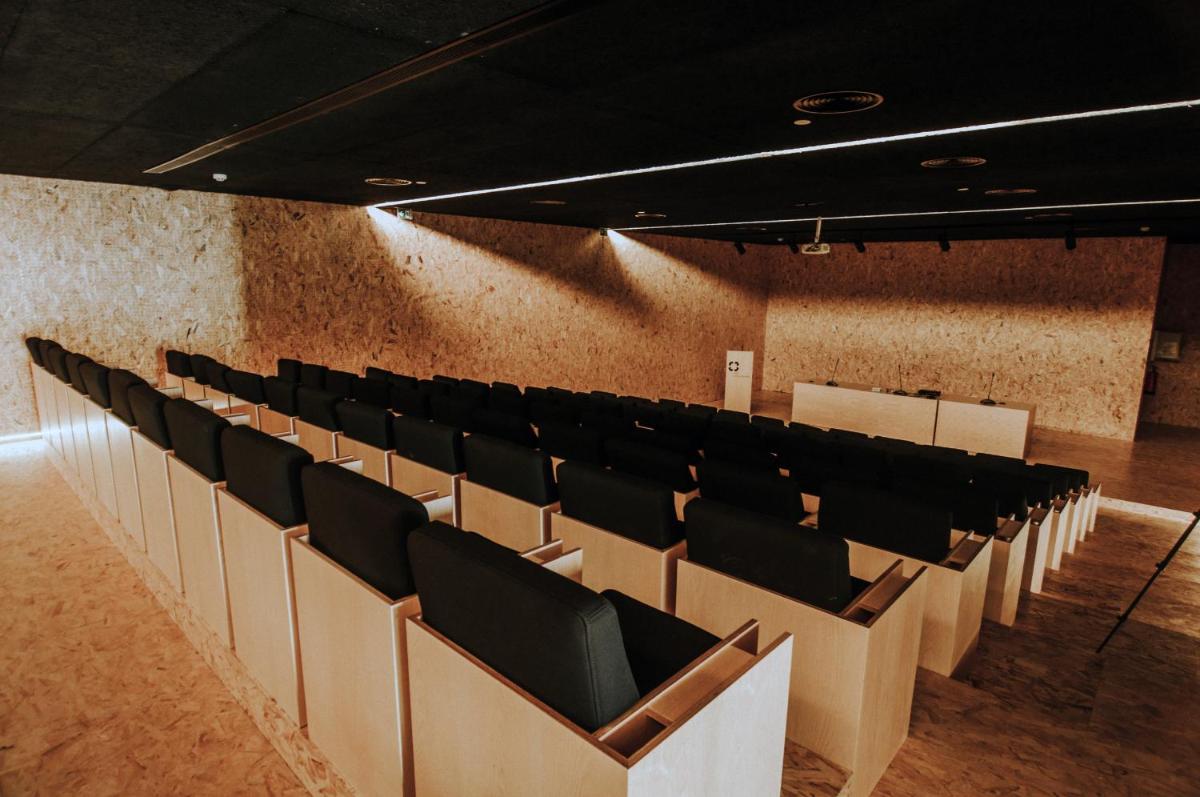 uma sala de conferências vazia com cadeiras pretas e uma parede em Cró Hotel Rural em Rapoula do Côa mais 44 fotografias