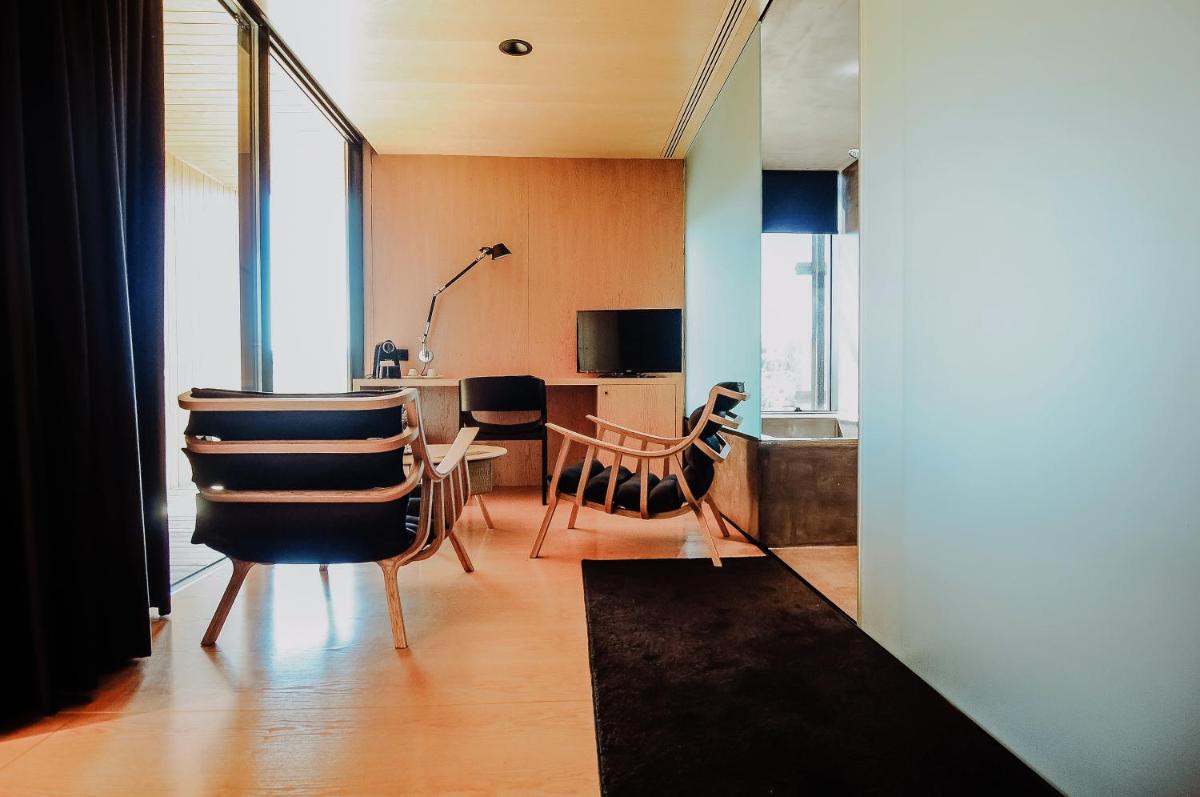 uma sala de estar com cadeiras e uma mesa com televisão em Cró Hotel Rural em Rapoula do Côa