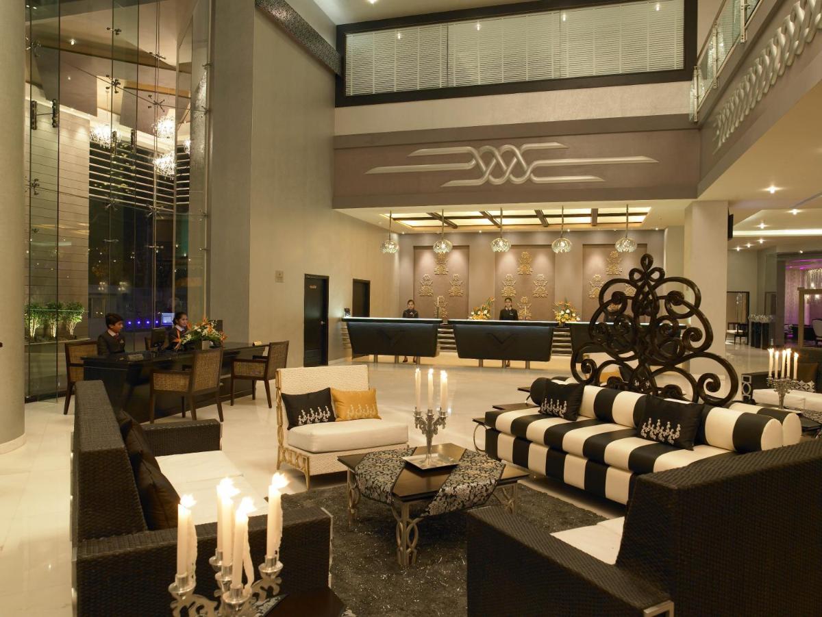 a lobby with couches and tables and a bar at The Zuri Whitefield Bengaluru in Bengaluru
