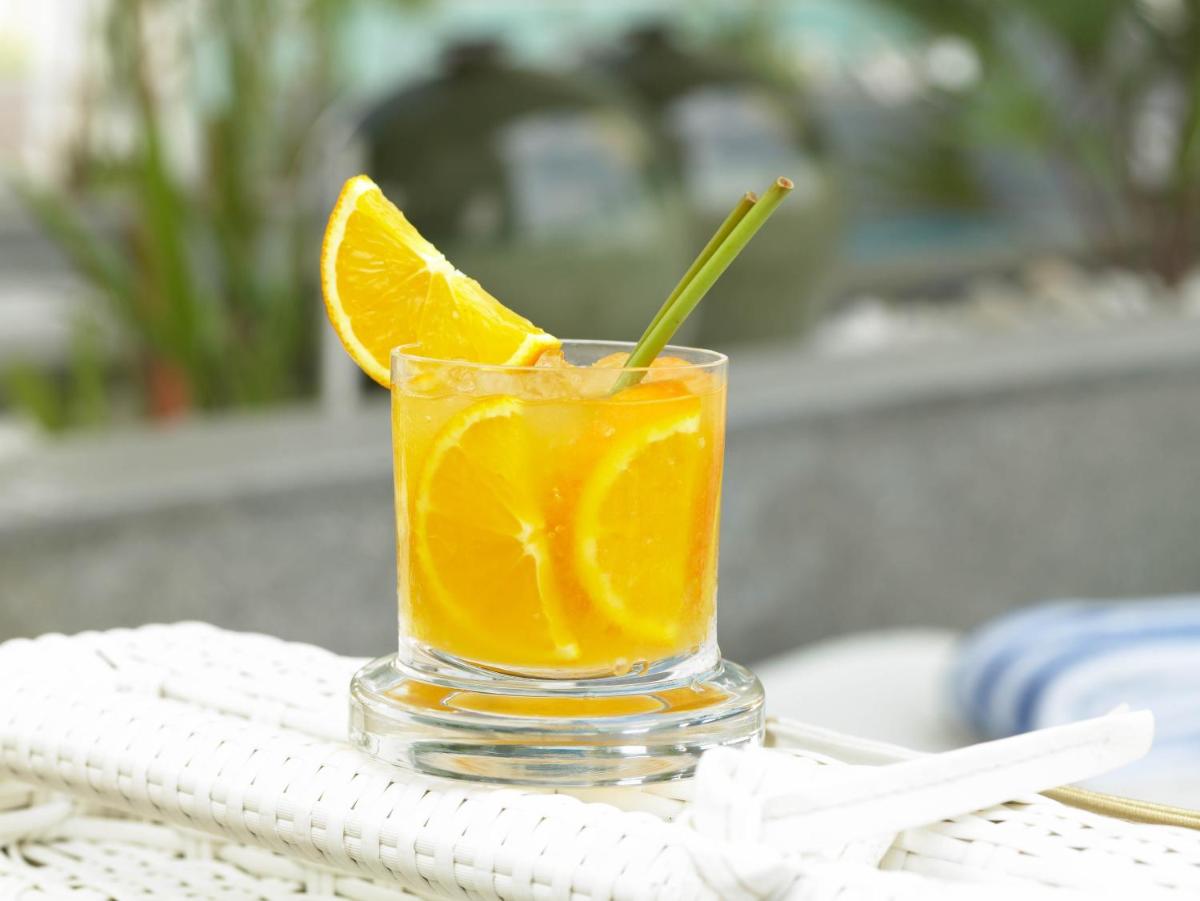 a glass of orange juice sitting on a table at The Zuri Whitefield Bengaluru in Bengaluru