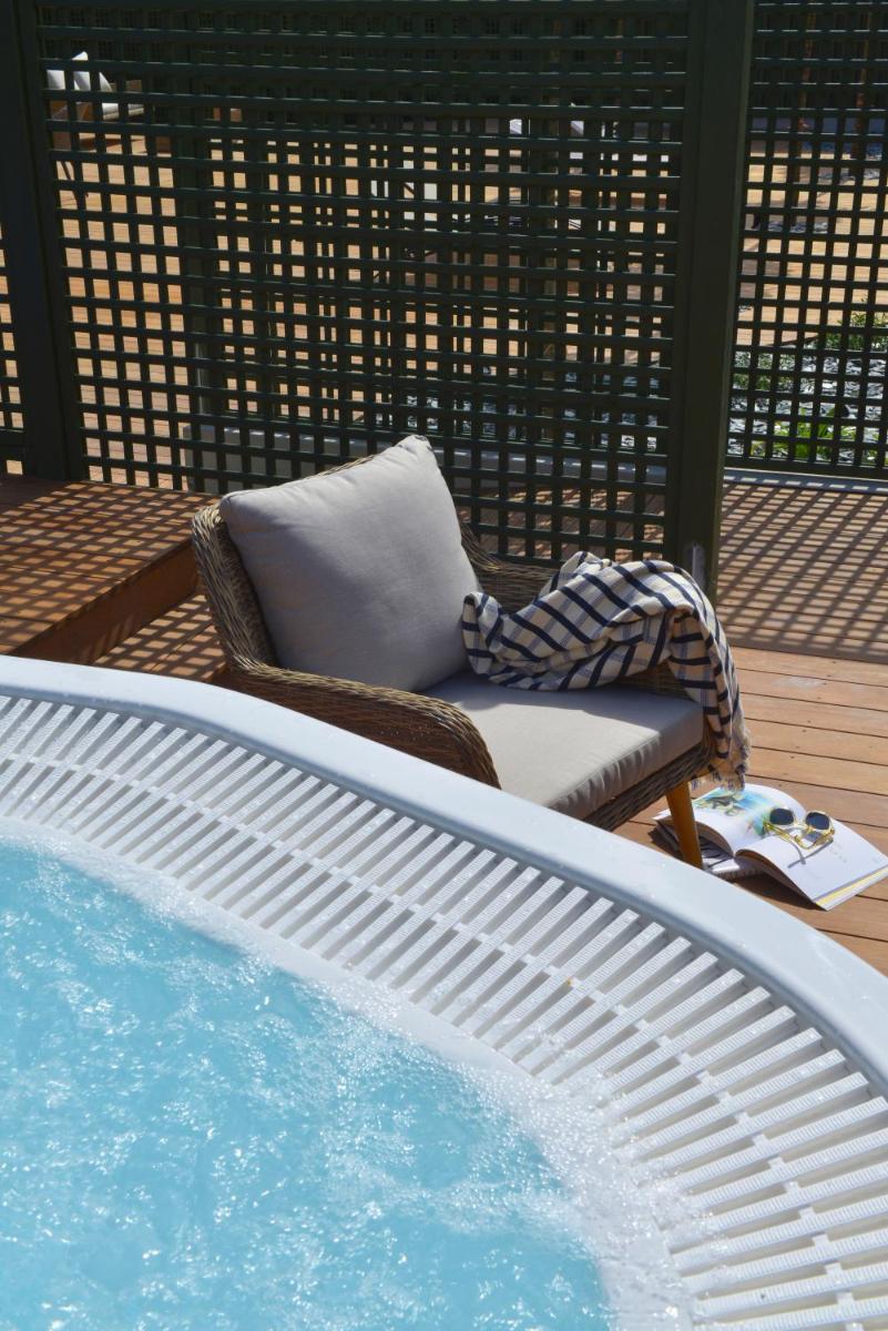 une piscine avec une chaise et un coussin à côté dans l'établissement Hotel De Diane, aux Sables-dʼOr-les-Pins