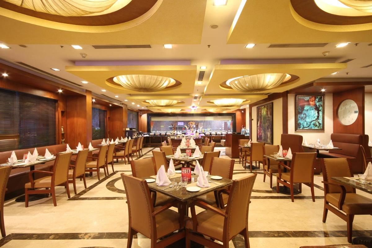 a restaurant with tables and chairs and a bar at Fortune Select JP Cosmos, Bengaluru - Member ITC Hotels' Group in Bengaluru