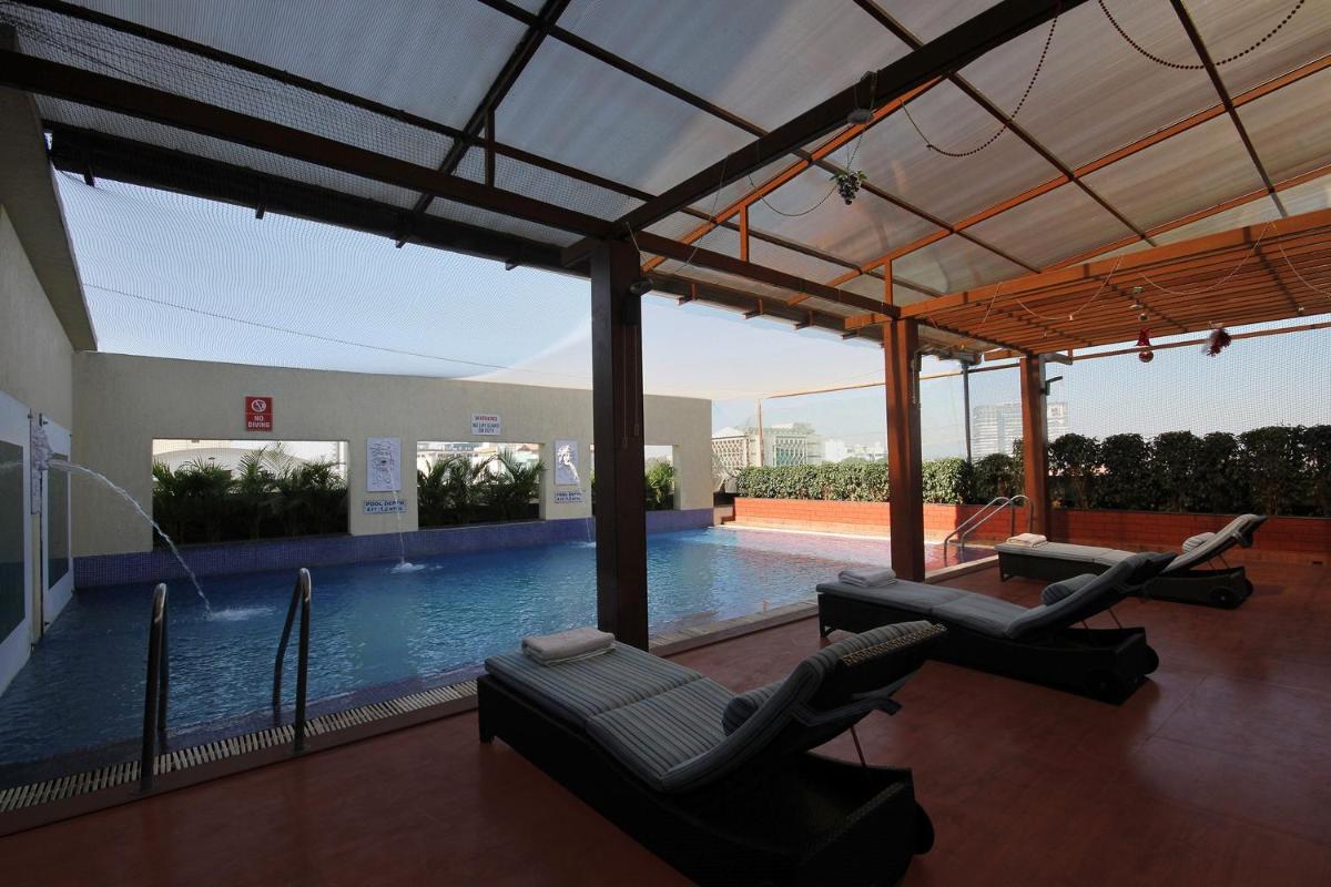 a swimming pool with lounge chairs in a building at Fortune Select JP Cosmos, Bengaluru - Member ITC Hotels' Group in Bengaluru