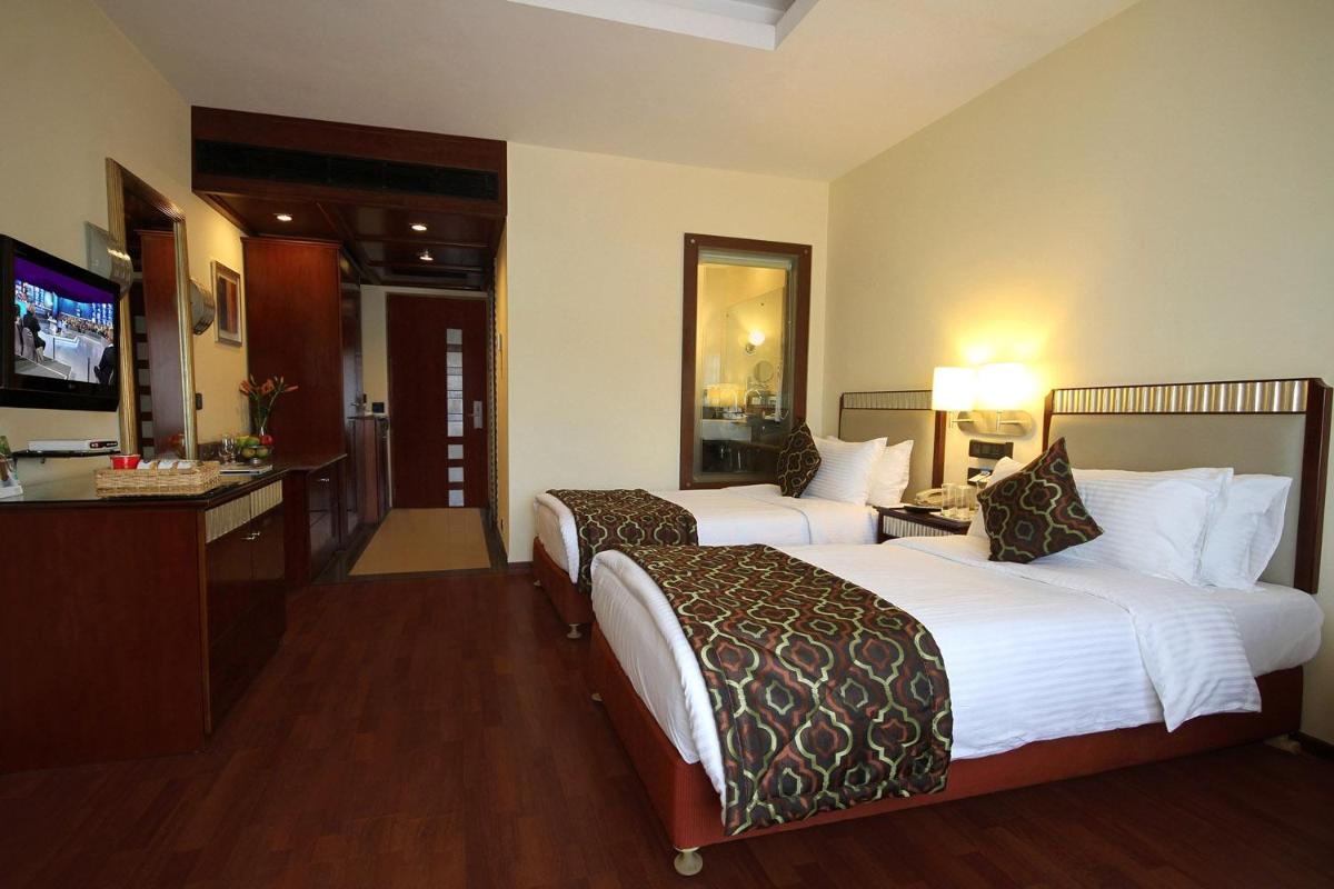 a hotel room with two beds and a television at Fortune Select JP Cosmos, Bengaluru - Member ITC Hotels' Group in Bengaluru