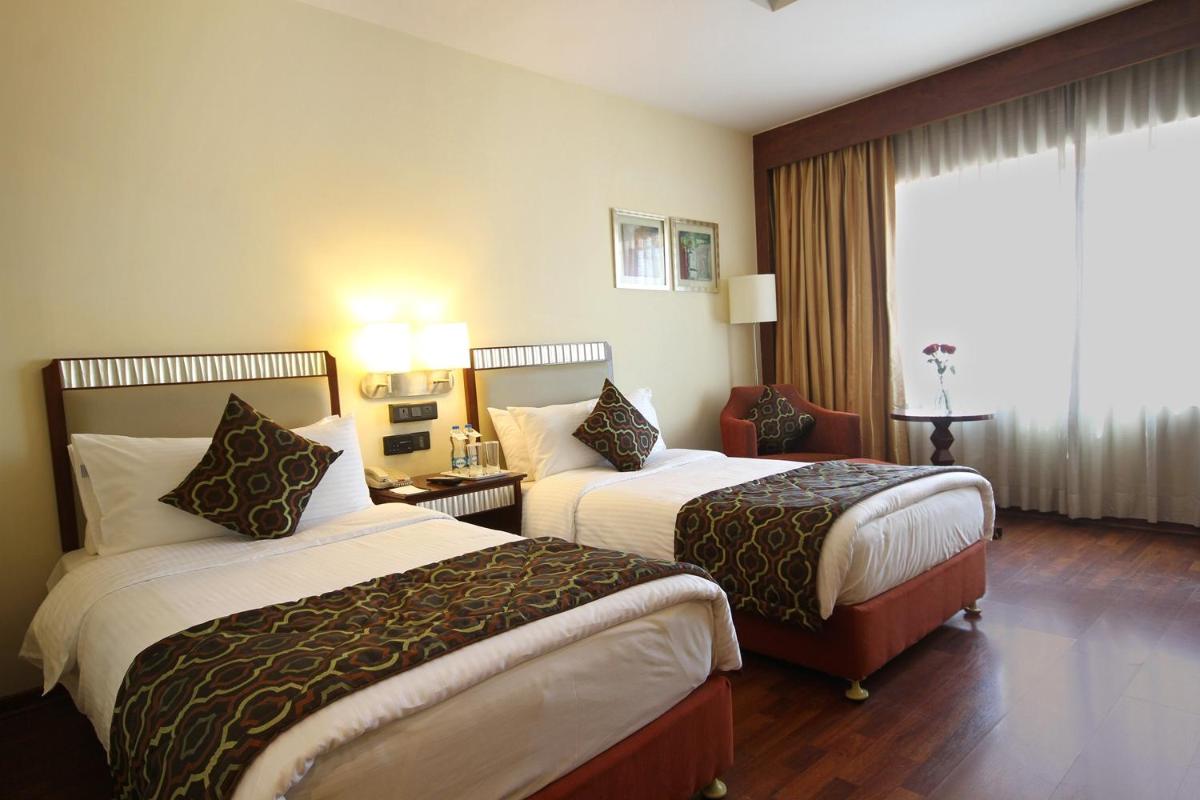 a hotel room with two beds and a window at Fortune Select JP Cosmos, Bengaluru - Member ITC Hotels' Group in Bengaluru