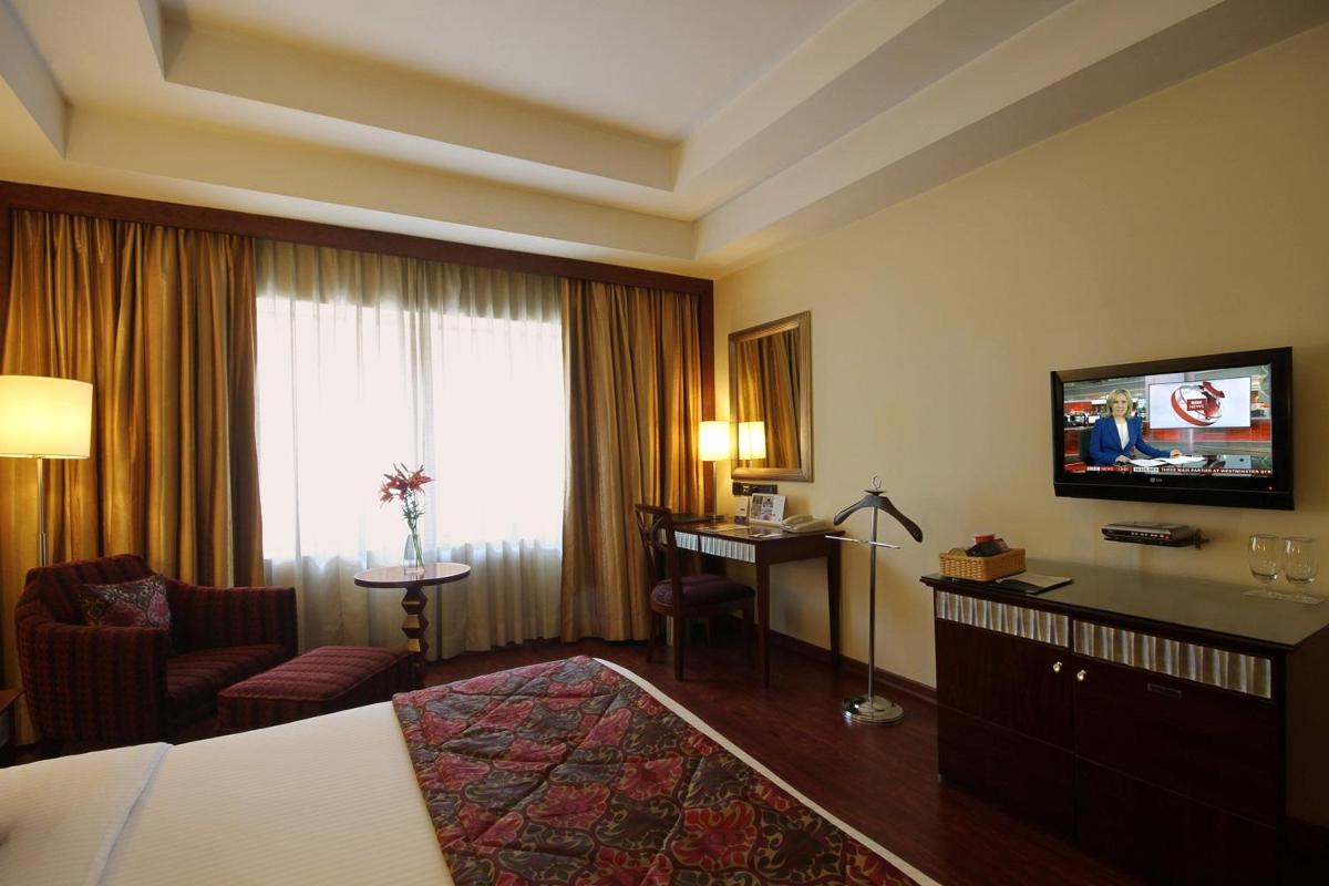 a hotel room with a bed and a television at Fortune Select JP Cosmos, Bengaluru - Member ITC Hotels' Group in Bengaluru