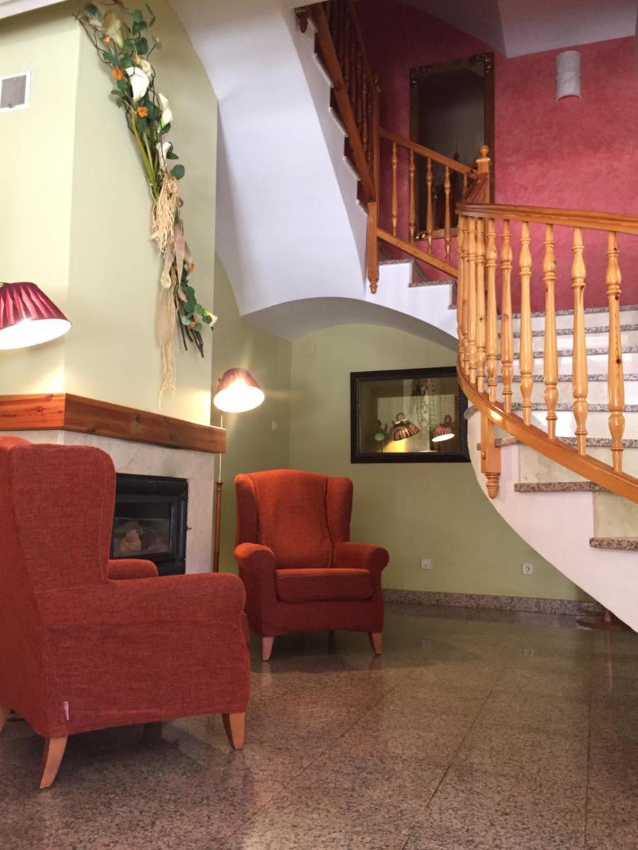 Una sala de estar con una silla y una chimenea. en Hotel Castellote, en Castellote