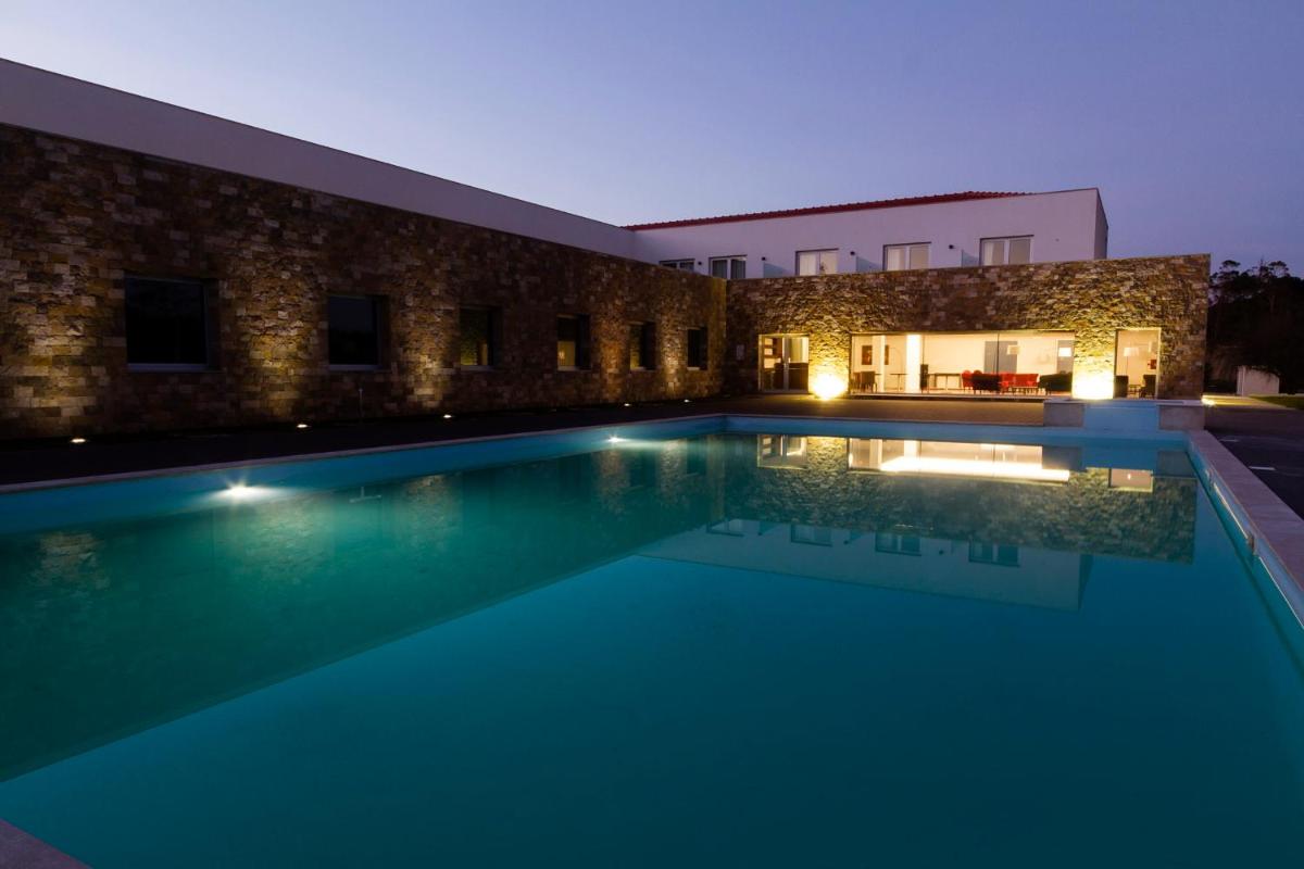 uma piscina em frente a um prédio à noite em Hotel Vila D'Óbidos em Óbidos