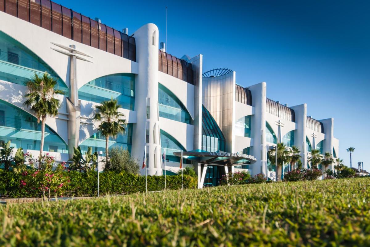 Un edificio con palmeras delante. en Senator Banus, en Estepona