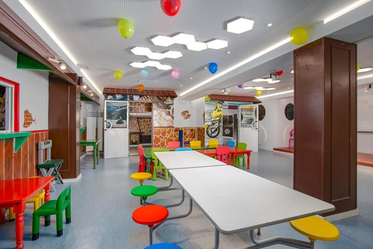 una clase con mesas, sillas coloridas y globos en el techo en Gran Hotel Las Fuentes, en Alcossebre