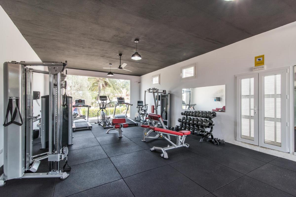 Un gimnasio con varios equipos de ejercicio en una habitación. en Hotel Na Taconera, en Cala Ratjada