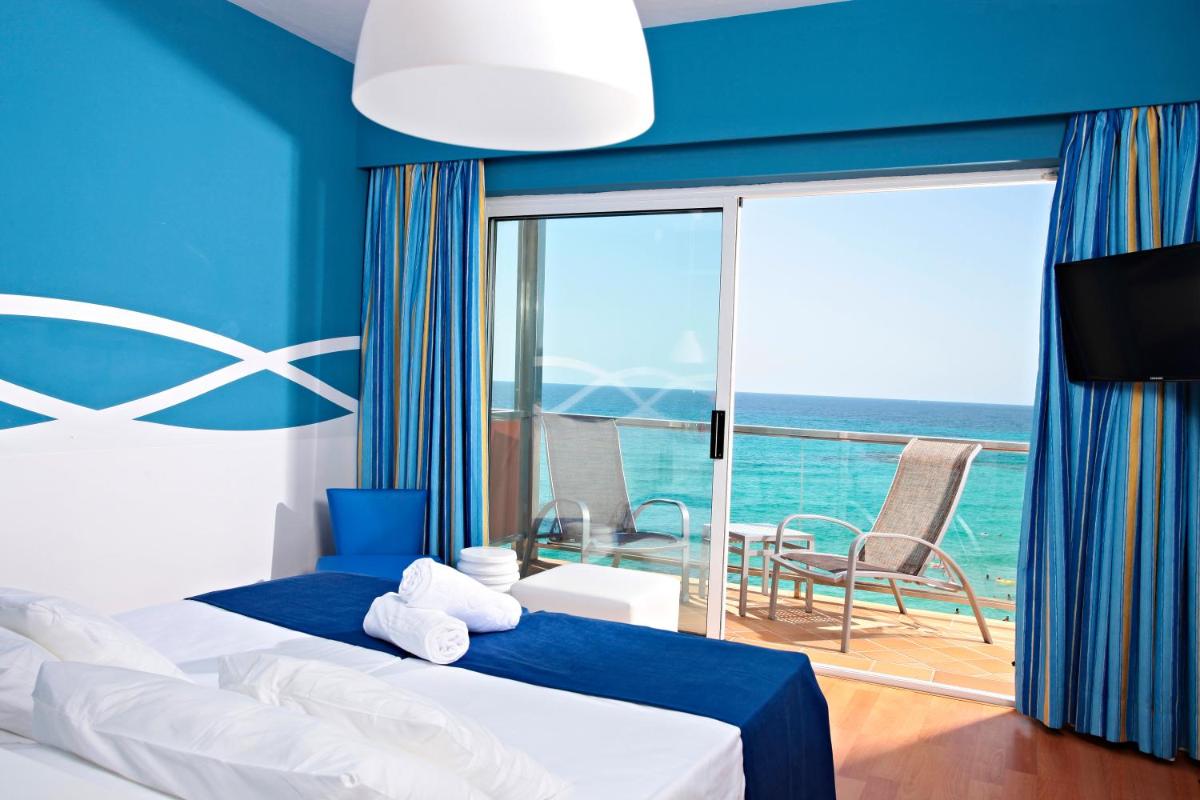 Un dormitorio con una cama y vista al mar. en Hotel Clumba, en Cala Ratjada