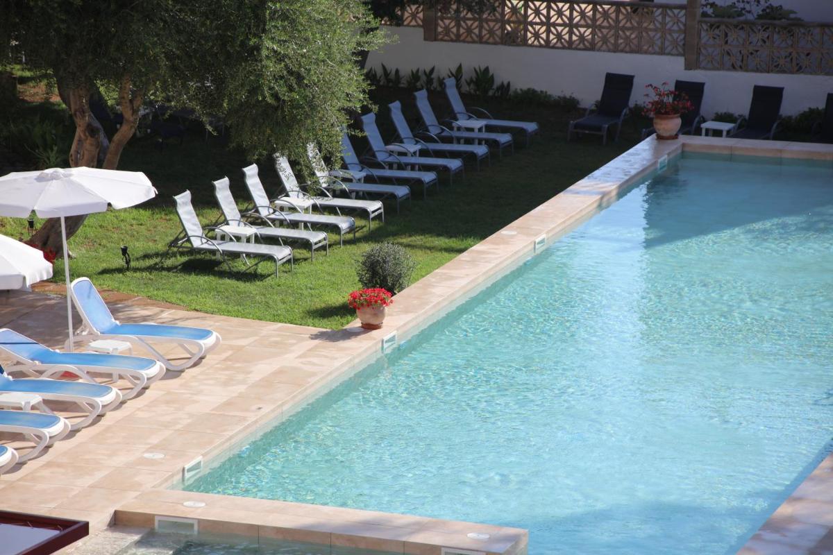 una piscina con tumbonas y un montón de plantas en Hotel Clumba, en Cala Ratjada 25 fotos más