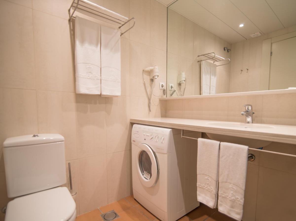 Un baño con lavadora y lavabo. en Aparthotel Ciutat de Palol, en Platja d'Aro
