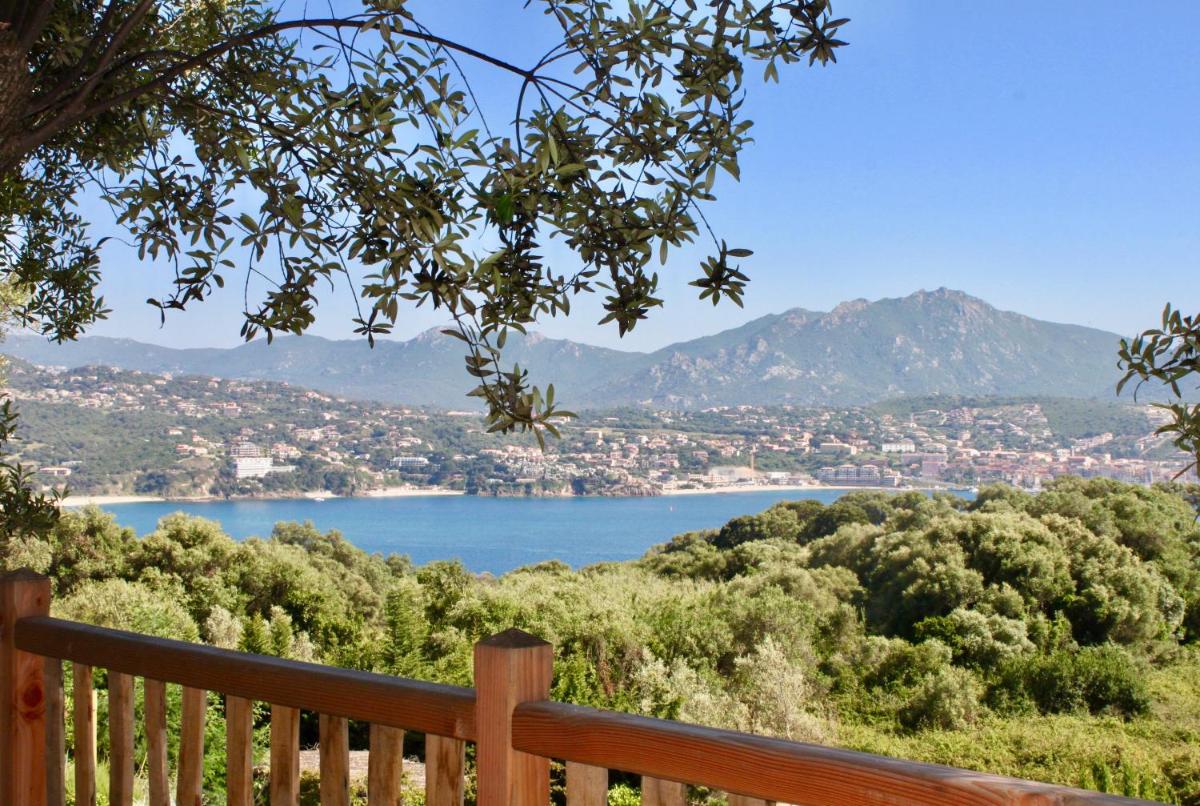 une vue sur un lac depuis un banc en bois dans l'établissement L'Hostellerie du Moulin des Oliviers, à Olmeto