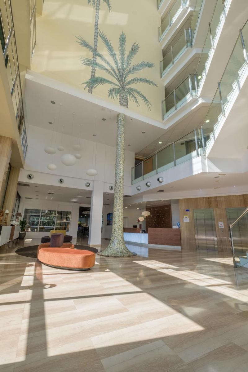 una palmera en medio de un vestíbulo en Hotel California Palace, en Salou