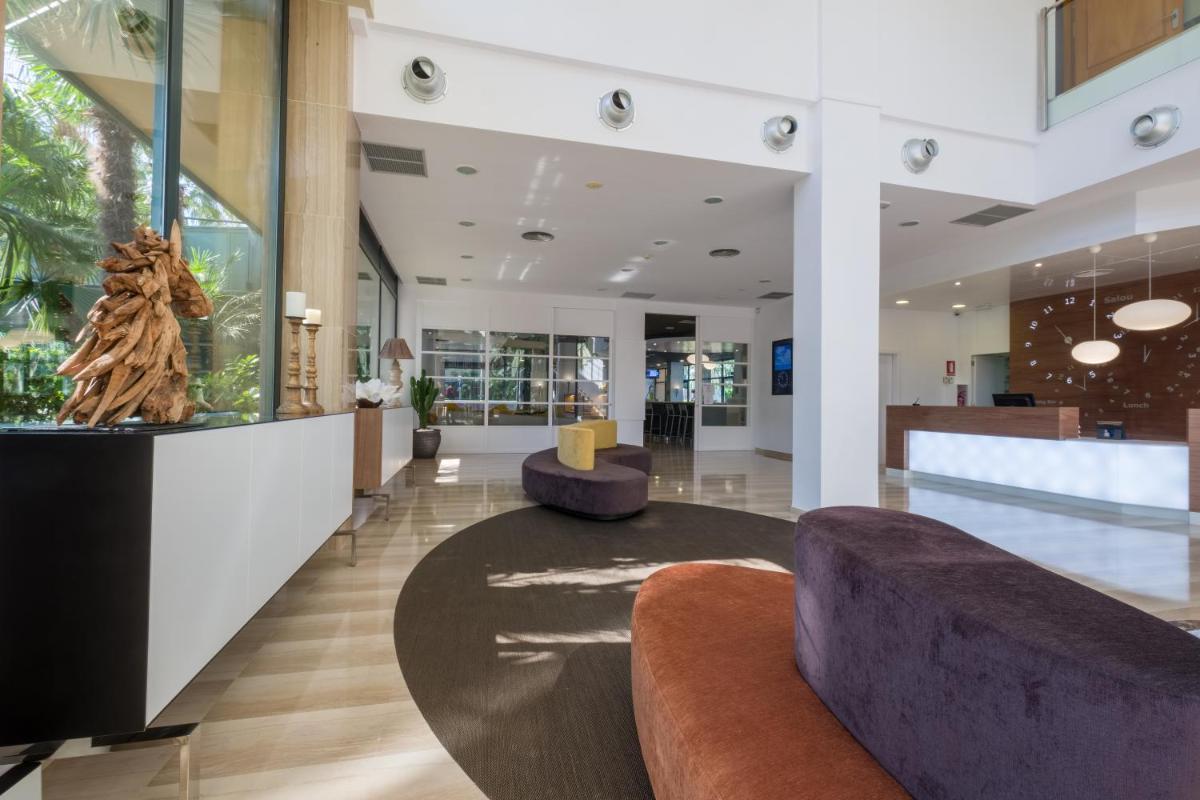 Un vestíbulo con un sofá y una mesa. en Hotel California Palace, en Salou