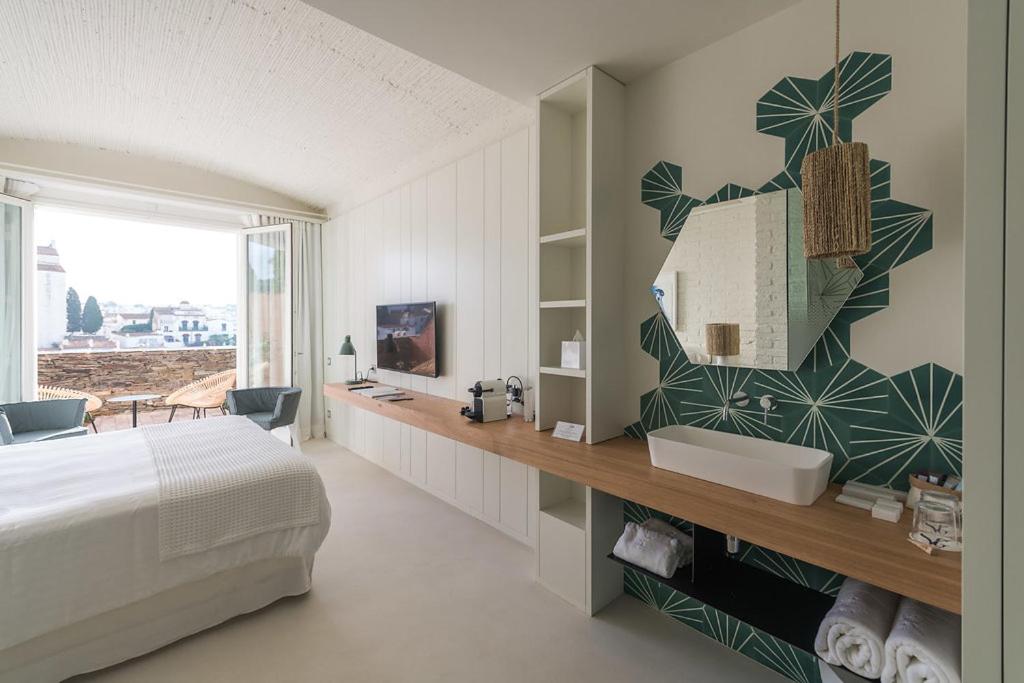 Un dormitorio con una cama y un baño con lavabo. en Boutique Hotel Villa Gala by Fimedhotels, en Cadaqués